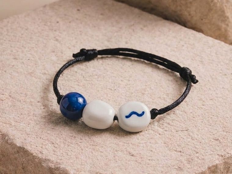 The bracelet for this brief: an indigo bead, a bone bead and a bone bead painted with a wave.