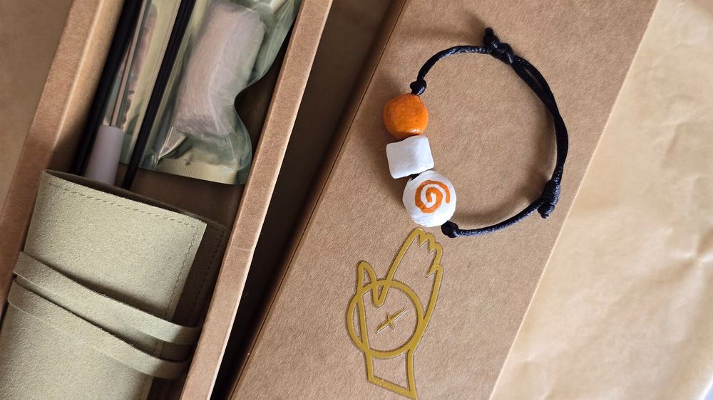 An open KEGO box with the finished bracelet inside.